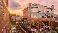 People dining during pink-tinted dusk on a rooftop in Brewer's Alley in Frederick, Maryland, USA