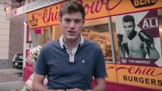 A reporter presenting in front of a food truck