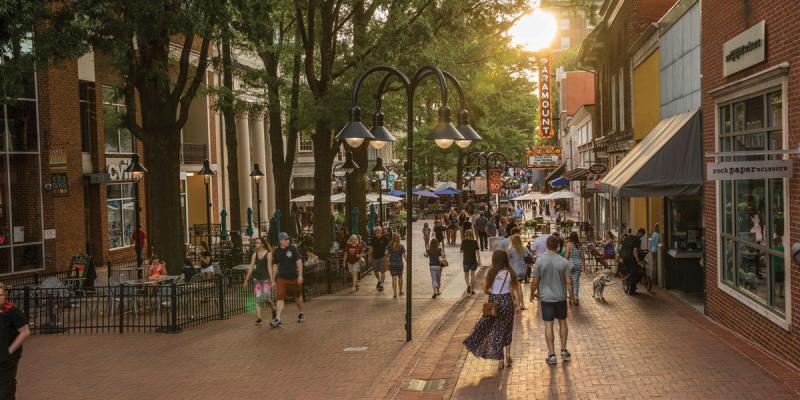 People walk on the brick streets of a tree-lined shopping area in the city centre of Charlottesville, Virginia, USA