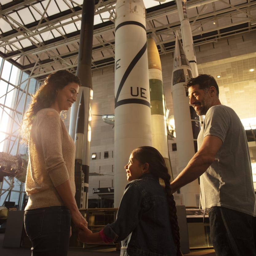 A family views a rocket in the museum exhibit hall