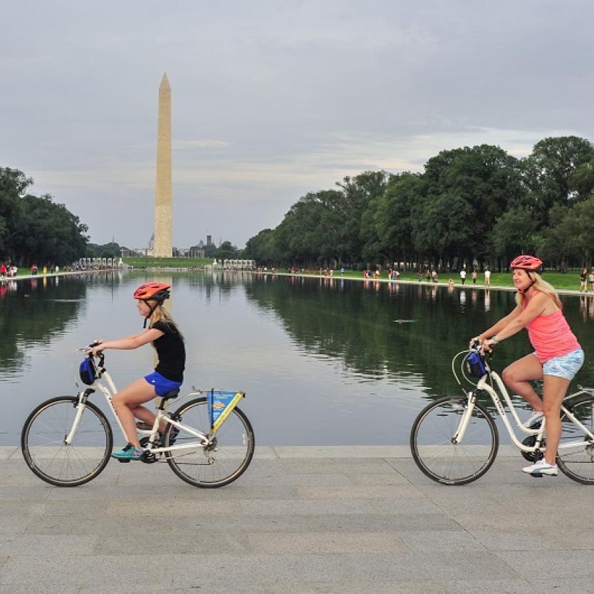 People biking past the Washington Monument on a tour with Bike & Roll in Washington, DC, USA
