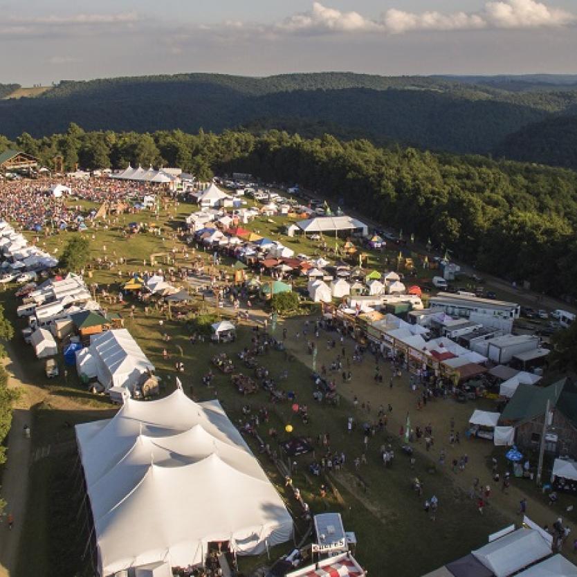 An aerial view of FloydFest, with white tents set amid the Blue Ridge Mountains of Virginia, USA.