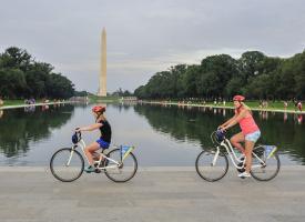 People biking past the Washington Monument on a tour with Bike &amp; Roll in Washington, DC, USA