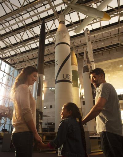 A family views a rocket in the museum exhibit hall