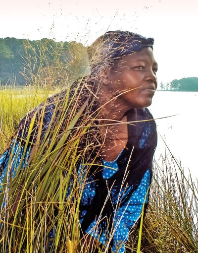 An actress portraying Harriet Tubman crouches among a field along the Harriet Tubman Underground Railroad Byway in Maryland, USA.